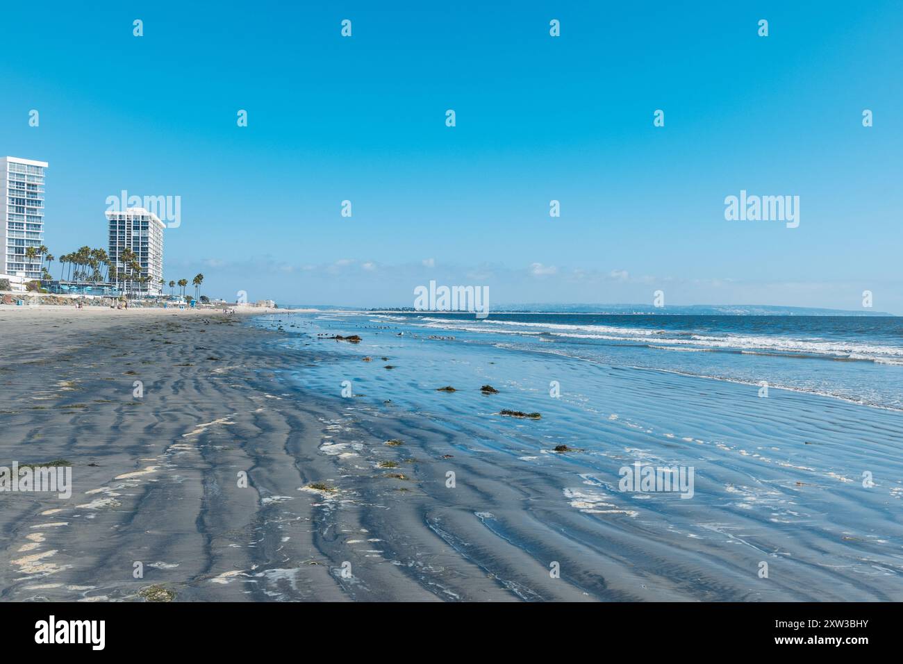 Vista panoramica lungo Coronado Beach, San Diego, California, con sabbia dorata, onde dolci, e un cielo azzurro. Una popolare destinazione costiera. Foto Stock