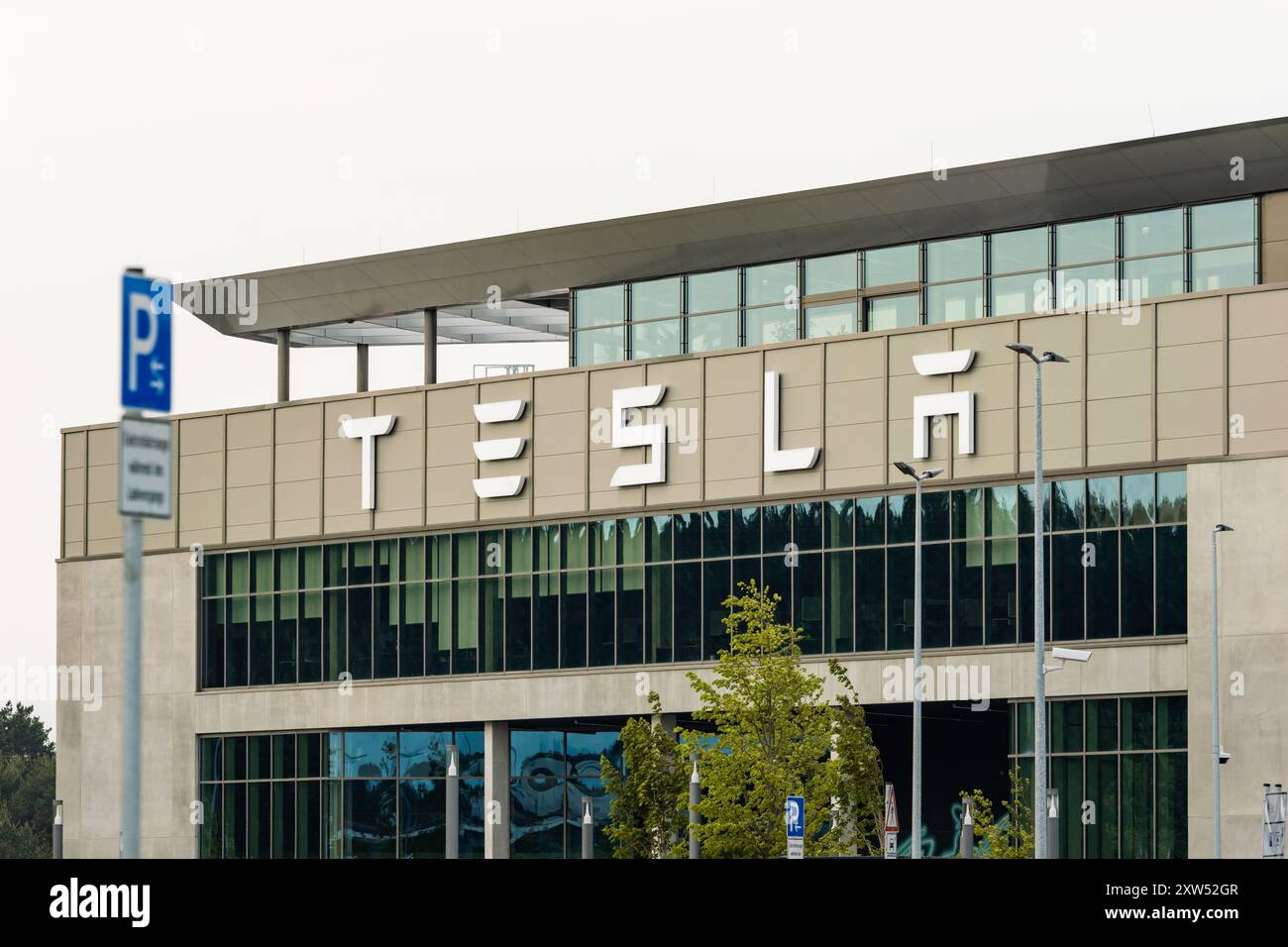 Tesla Gigafactory con il logo dell'azienda americana di auto elettriche. Grande datore di lavoro nella regione di Brandeburgo e Berlino (Grünheide) Foto Stock