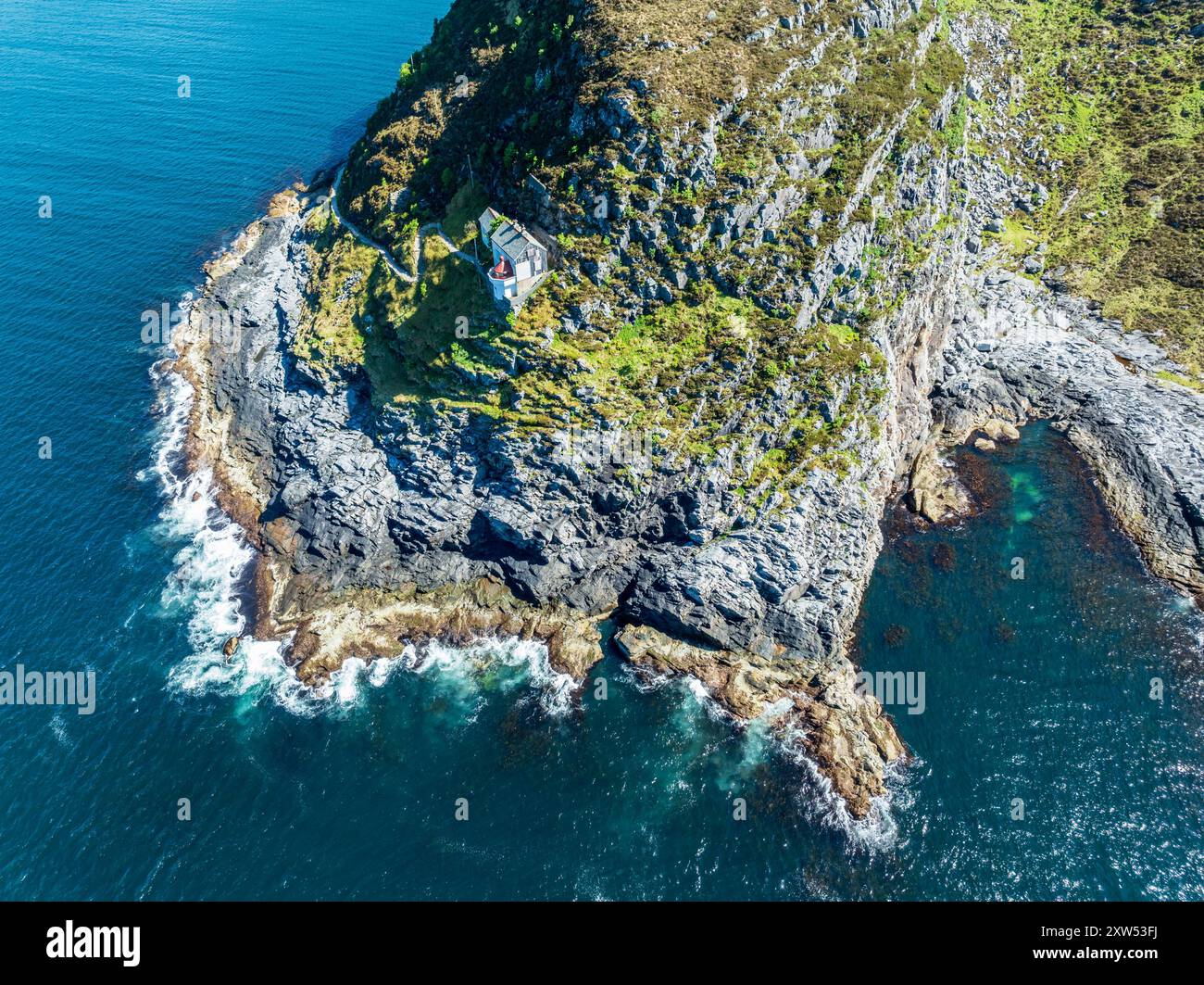 Veduta aerea del faro Hendanes Fyr, faro situato su una ripida scogliera, costa norvegese a ovest di Maloy, Vestland, Norvegia Foto Stock