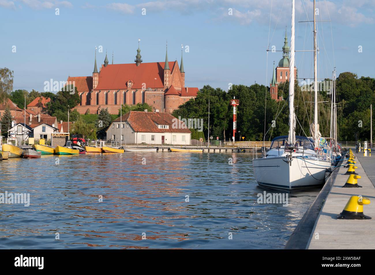 La barca e il traghetto sono illuminati dal sole e la cattedrale gotica sono a poca distanza Foto Stock