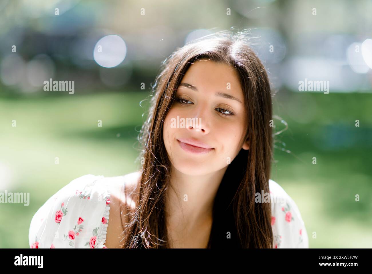 Primo piano felice sorridente bella giovane latina adolescente femminile seduto parco Foto Stock