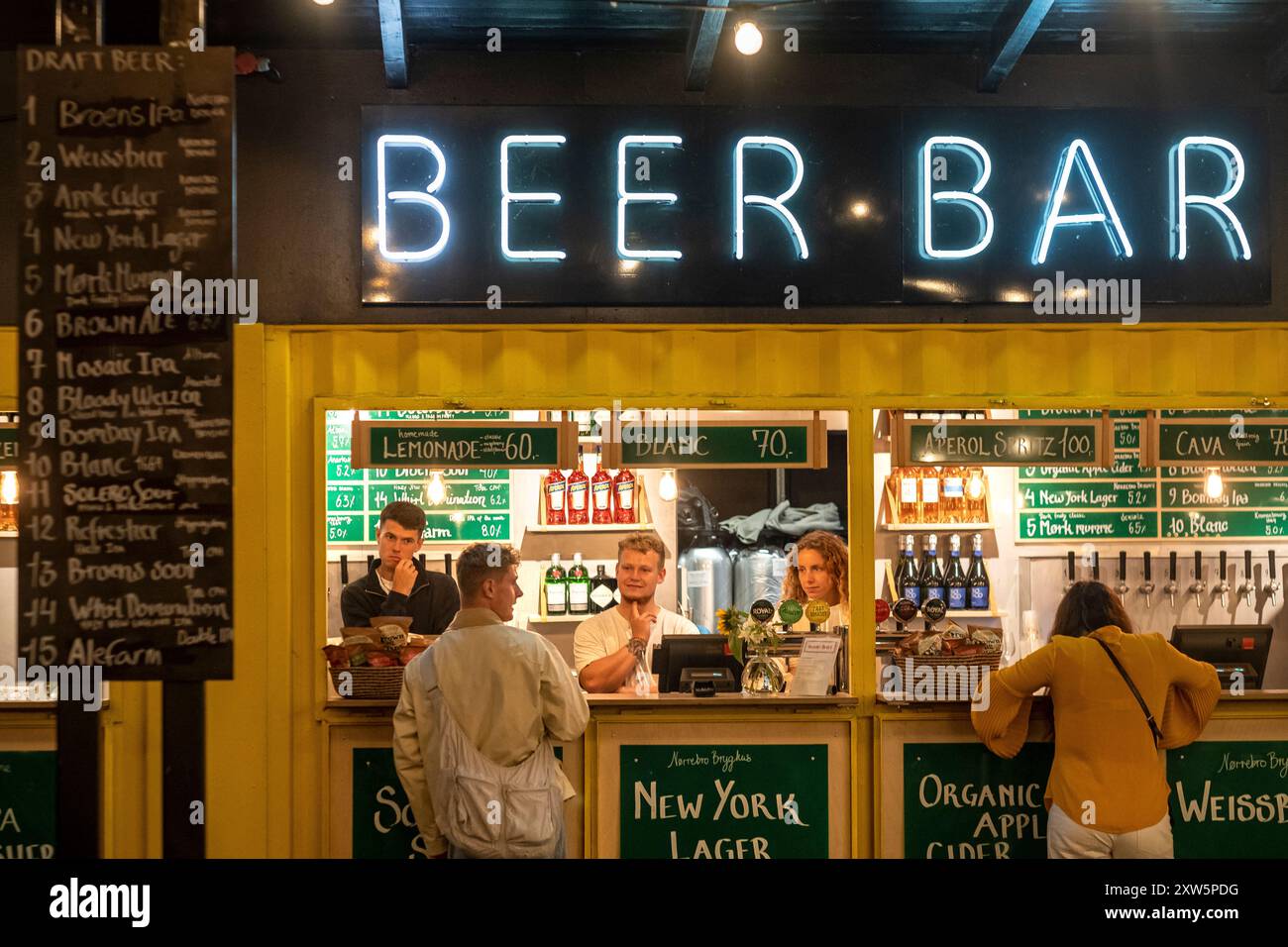 Gente che ordina una birra al mercato alimentare all'aperto di Broens, Copenhagen, Danimarca Foto Stock