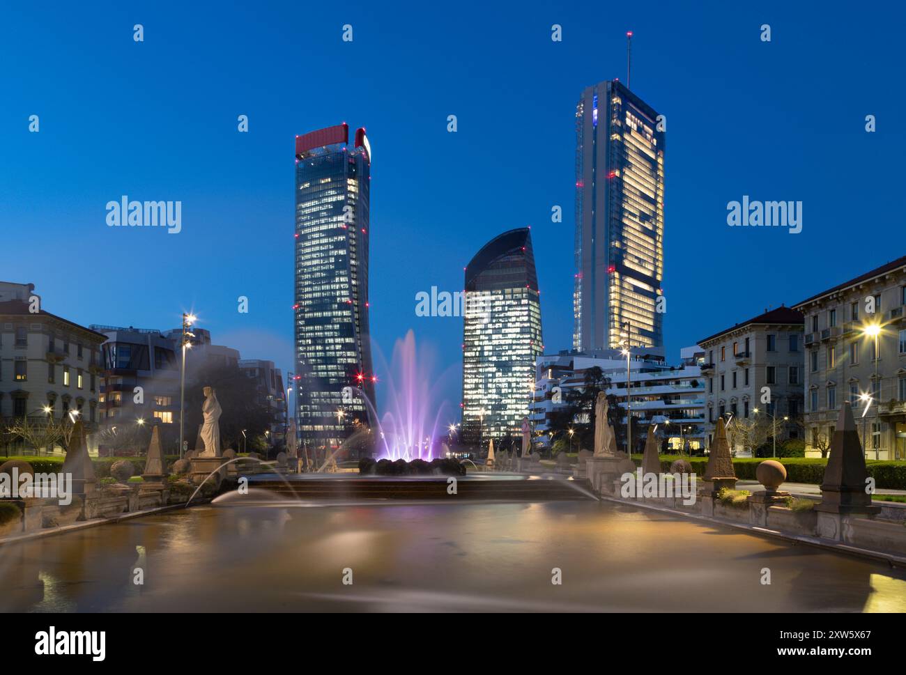 MILANO, ITALIA - 7 MARZO 2024: La fontana Fontana delle Quatro stagioni e i grattacieli della vita cittadina al crepuscolo. Foto Stock