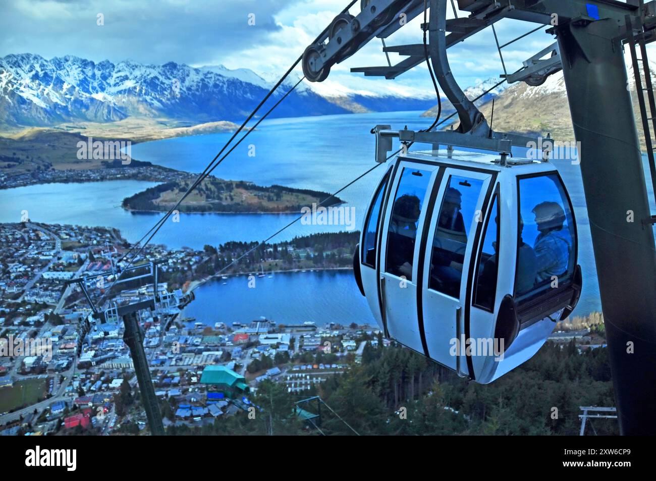 Gondola turistica si innalza al di sopra della cittadina di Queenstown, in Nuova Zelanda con il lago di Wakatipu in background. Foto Stock