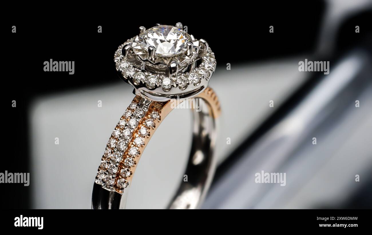 anello in oro bianco e oro rosa con diamanti, con sfondo nero Foto Stock