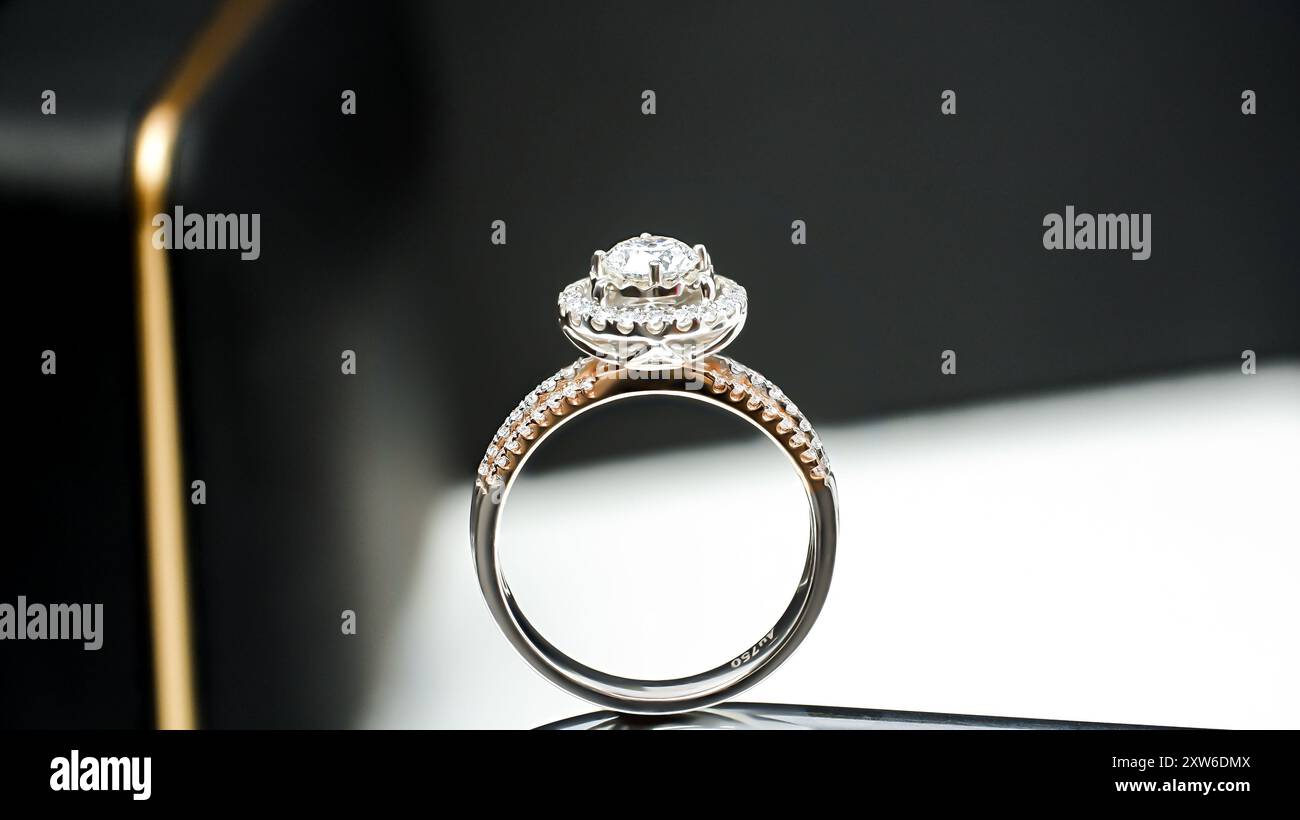 anello in oro bianco e oro rosa con diamanti, con sfondo nero Foto Stock