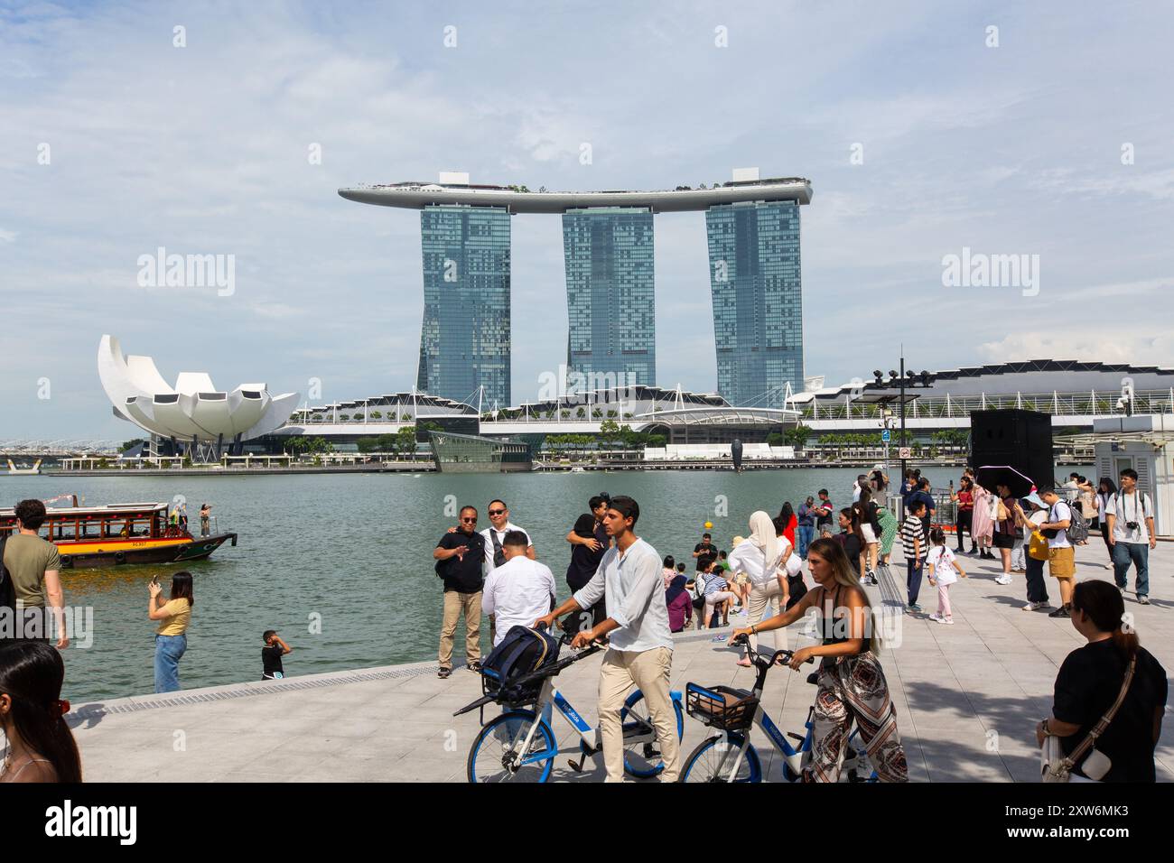 Esplora Marina Bay Sands, dove la folla di turisti sperimenta un mix di lusso moderno e spettacolari vedute del paesaggio urbano, rendendolo un punto di forza. Singapore. Foto Stock