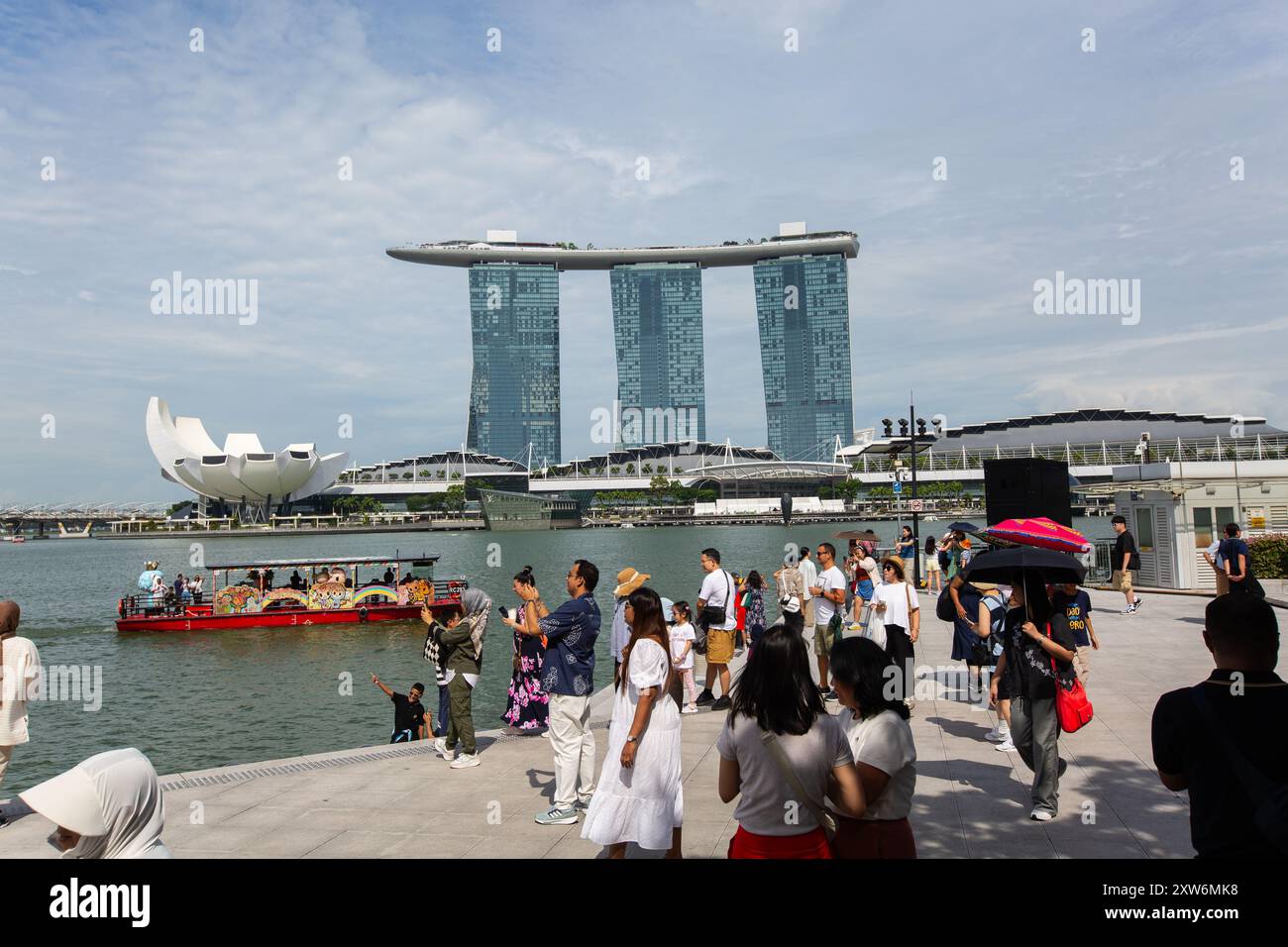 I turisti si affollano a Marina Bay Sands di Singapore per la sua splendida architettura, le viste panoramiche della città e i servizi di classe mondiale, rendendolo una visita imperdibile Foto Stock