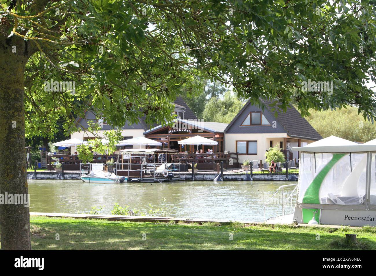 Blick am Freitag 16.08.2024 unweit von Verchen Mecklenburgische Seenplatte auf das Areal an der Aaalbude. An der Aalbude verbindet der Fluss Peene auf natürliche Weise die Landesteile Mecklenburg und Vorpommern. Dazu kann man an dem Kleinod mit dem Rad oder zu Fuß zu einem Ausflug in den Naturpark Mecklenburger Schweiz / Kummerower SEE starten beziehungsweise den Flusslauf während der Sommersaison mit einer Fähre überqueren. Außerdem gibt es die Gelegenheit, direkt am Wasser regionale Köstlichkeiten zu genießen und den Booten bei der Einfahrt in den Kummerower SEE nachzuschauen. Quindi, ID filiera dorata Foto Stock