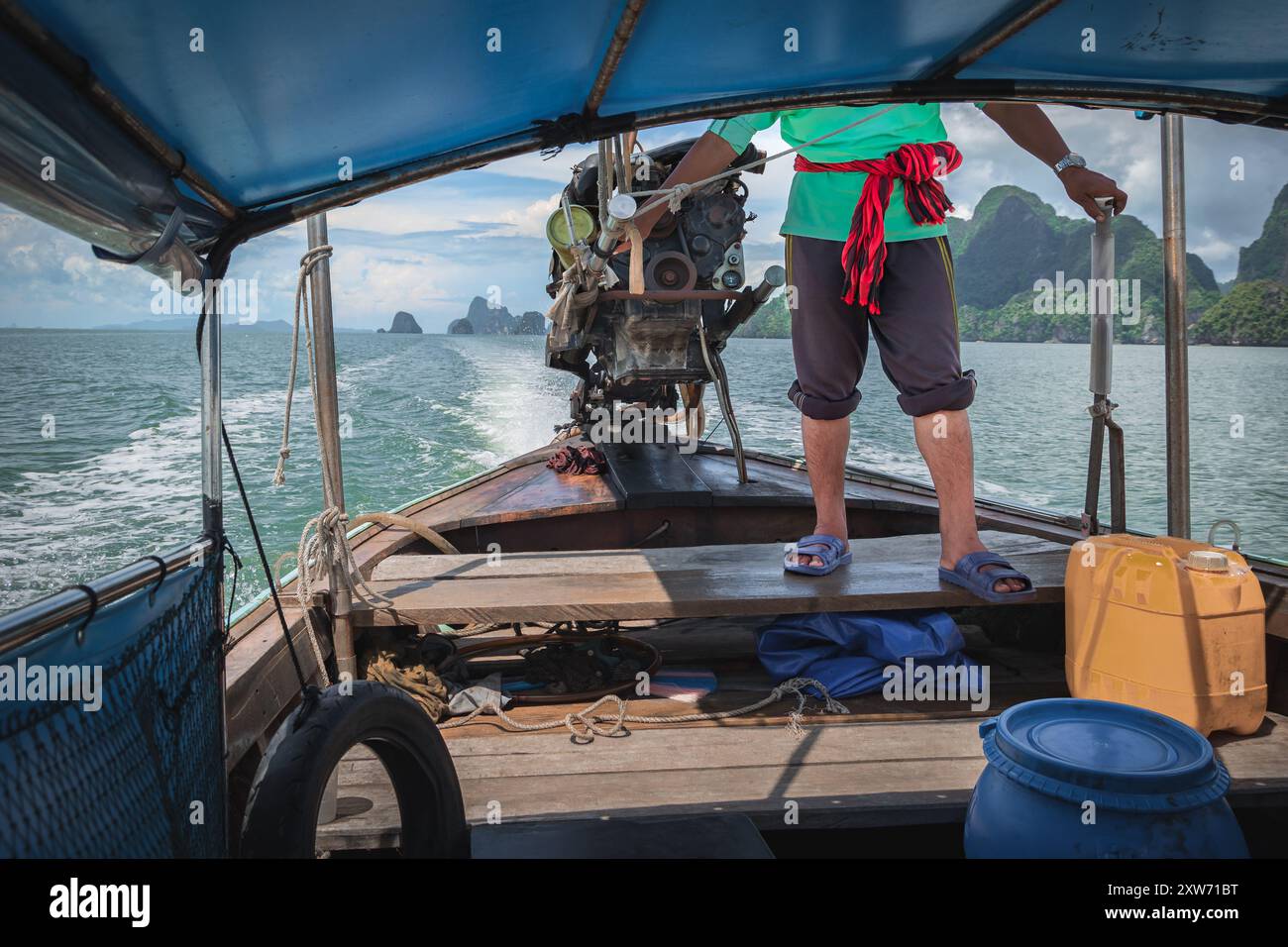 Phuket Thailandia ritratto dell'uomo che guida la barca in un giorno d'estate. I pescatori guidano una tradizionale barca tailandese a coda lunga in Thailandia. Foto di viaggio Foto Stock