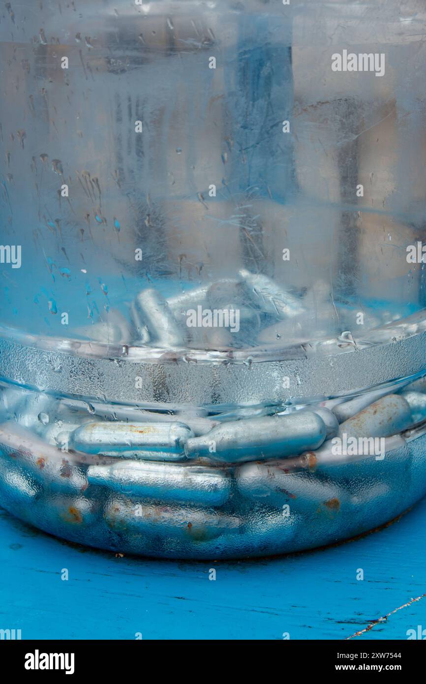 bulbi vuoti di protossido di azoto raccolti dalla strada per il riciclaggio, noti anche come gas ridendo o droga ricreativa hippie crack Foto Stock