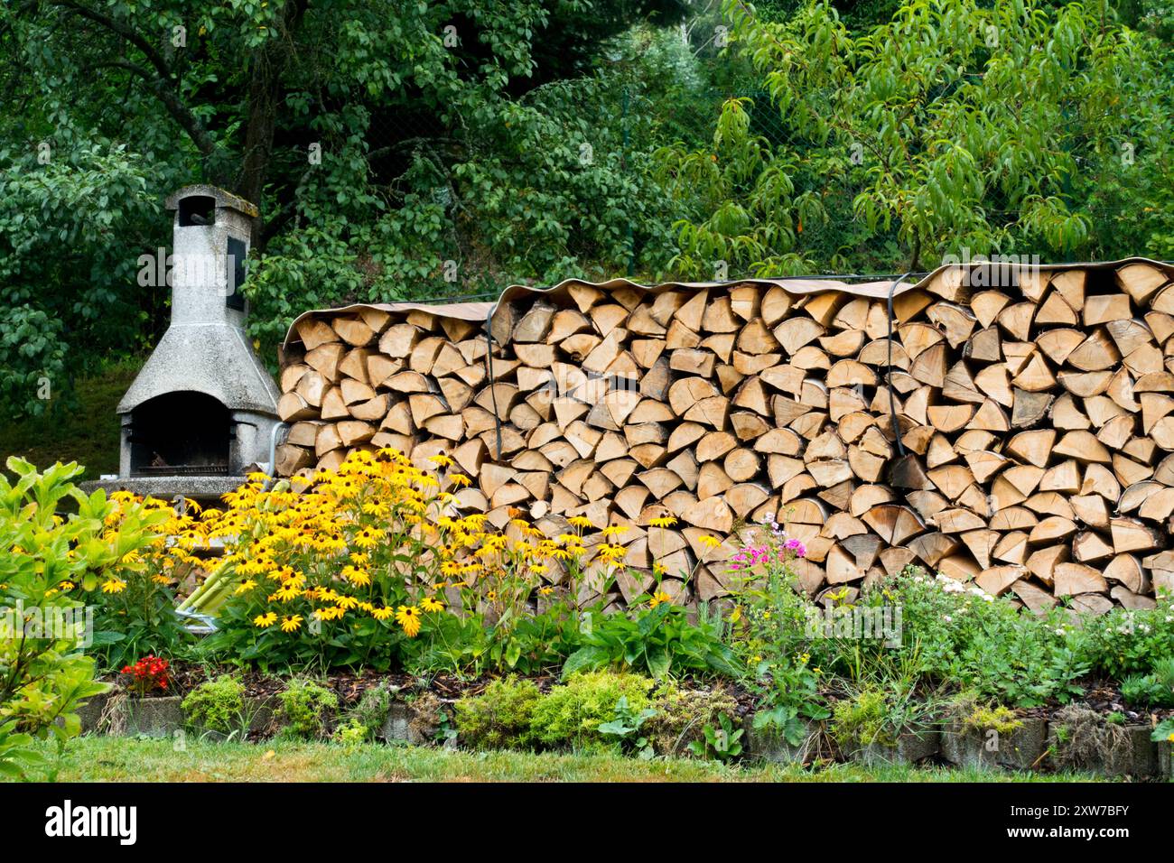 Caminetto da giardino e legna conservata per l'inverno, tagliata, legname, stoccaggio, legna da ardere secca, pelo, asciugatura loghi in legno impilati, impilati Foto Stock