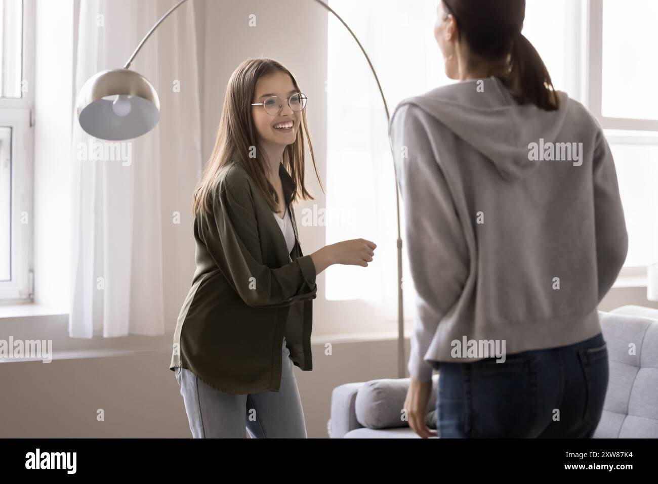 Ragazza adolescente felice che balla con musica energica con la madre Foto Stock