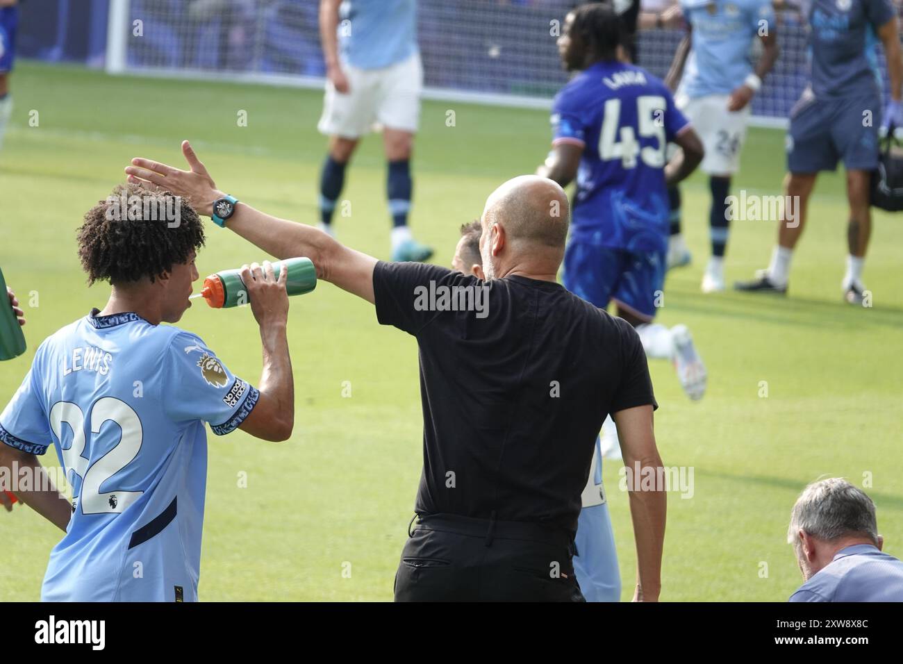Chelsea, Londra, Regno Unito. 18 agosto 2024. La prima partita della Premier League per il Chelsea Football Club e gli ultimi anni i campioni del Manchester City Football Club giocavano allo Stamford Bridge. Our Picture Shows: (OPS) : Man City Coach Guardiola gesticolano il lato del campo, mentre il suo giocatore Rico Lewis beve il gatorade. Crediti: Motofoto/Alamy Live News Foto Stock