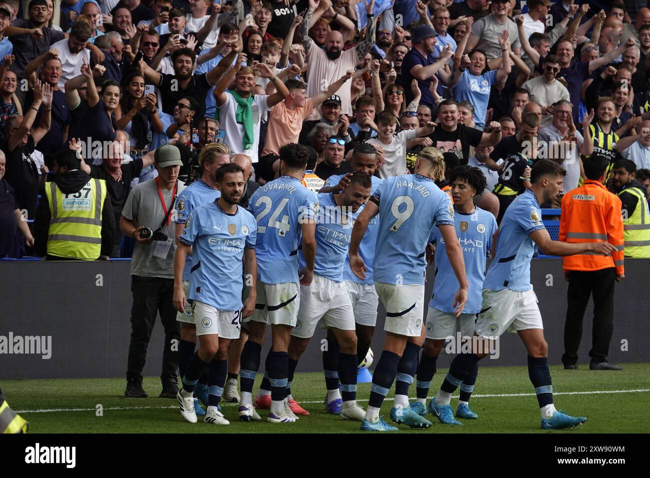Chelsea, Londra, Regno Unito. 18 agosto 2024. La prima partita della Premier League per il Chelsea Football Club e gli ultimi anni i campioni del Manchester City Football Club giocavano allo Stamford Bridge. Our Picture Shows: (OPS) : l'uomo CityÕs Kovacic segna un gol brillante e riceve gli applausi dei suoi tifosi e gli abbracci dai suoi compagni di squadra al Shed End. Crediti: Motofoto/Alamy Live News Foto Stock