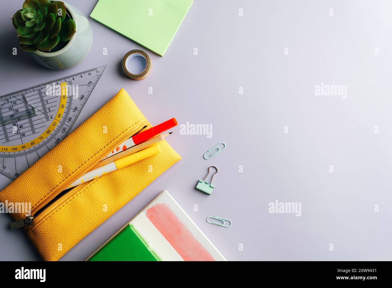 Forniture scolastiche, blocco note, astuccio giallo, matita, righello, penne succulente per piante e feltro su sfondo lilla. Vista dall'alto, disposizione piatta, spazio di copia. Foto Stock