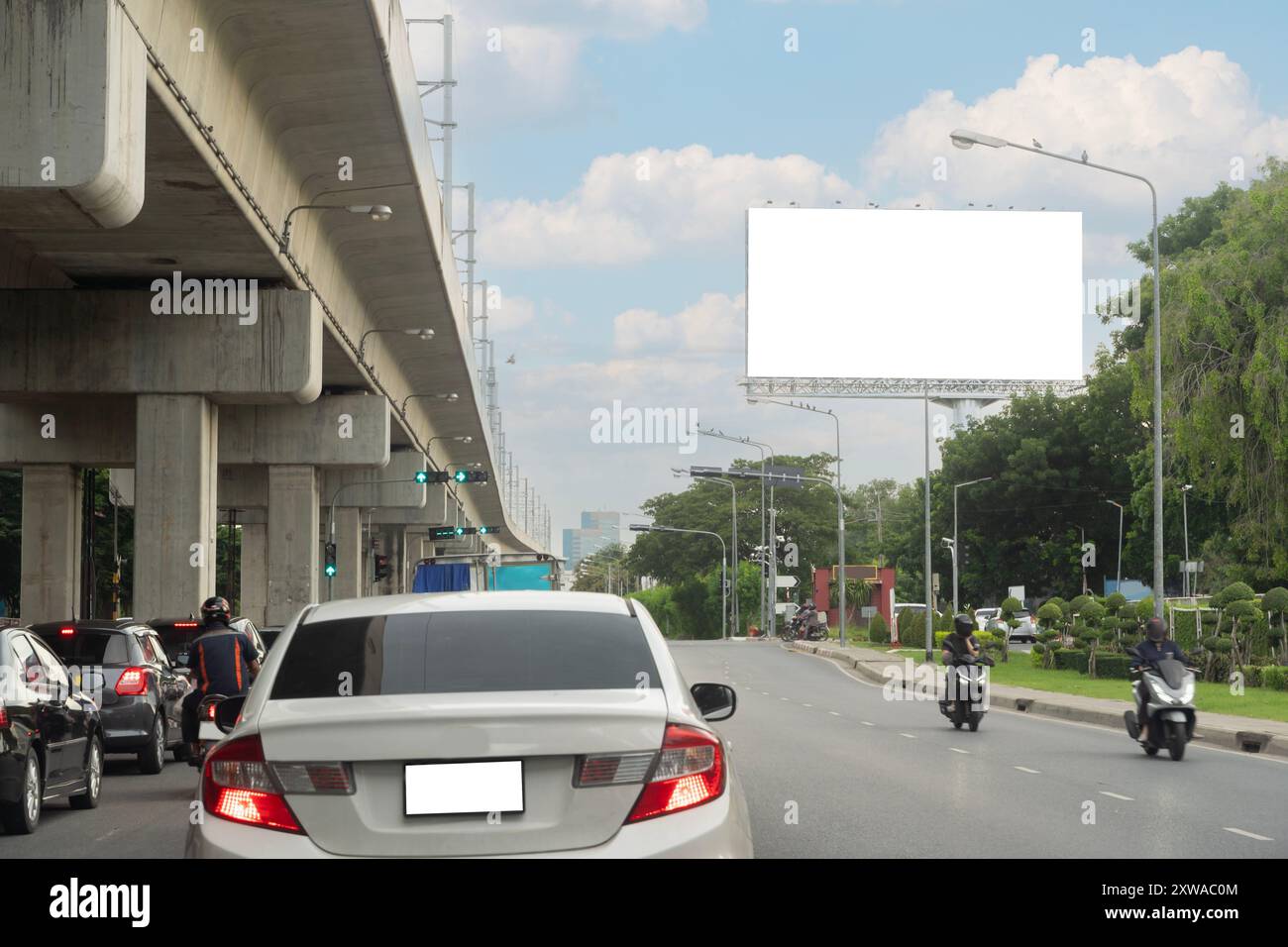 Strada con lanterne e grande cartellone bianco in serata nella città di Bangkok. Thailandia. Mock up bianco tabellone verticale vuoto sulla strada della città, ritagliato Foto Stock
