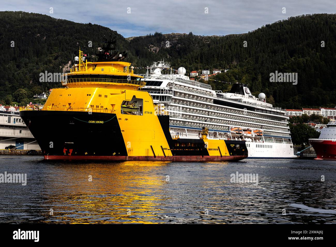 Fornitura offshore AHTS Odin Viking che naviga indietro nel porto di Bergen, Norvegia. Passando per la nave da crociera Viking Sky Foto Stock