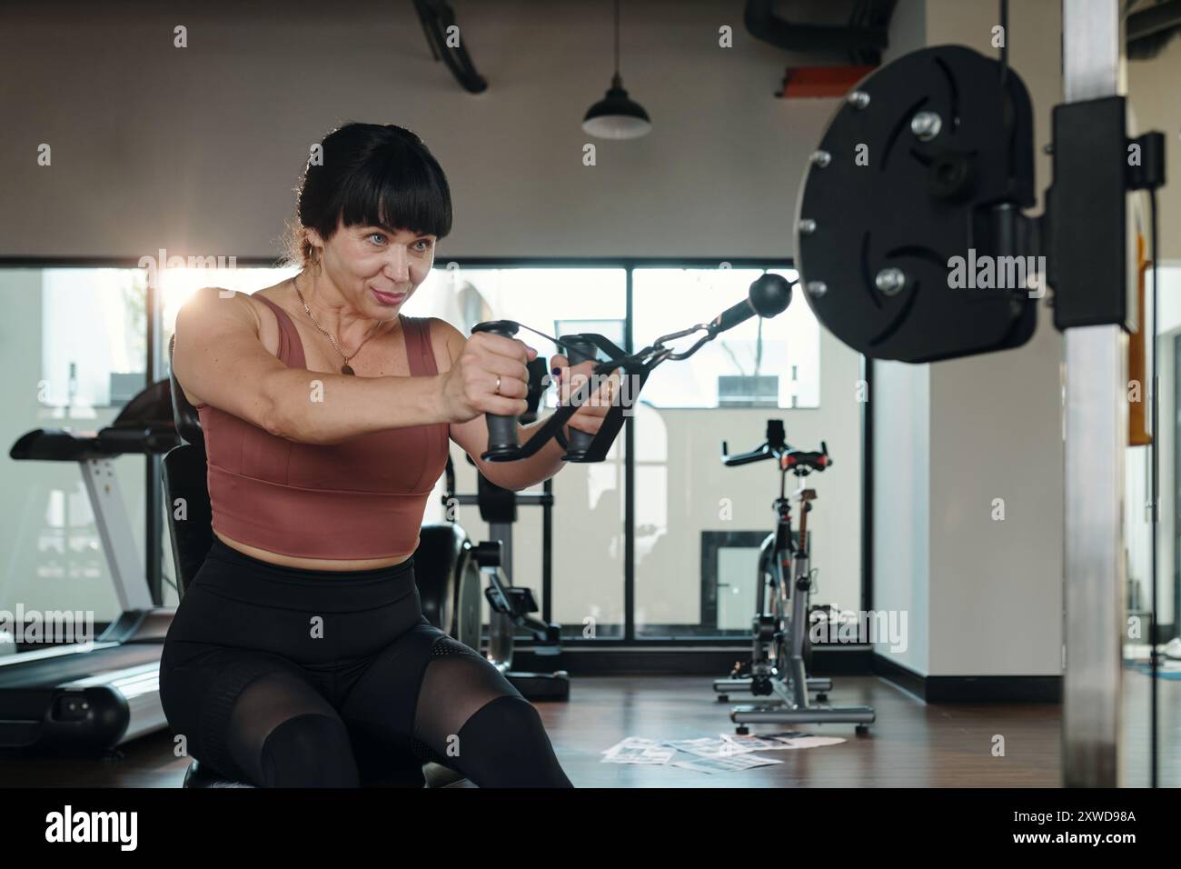 Donna che si allena con pesi in palestra Foto Stock