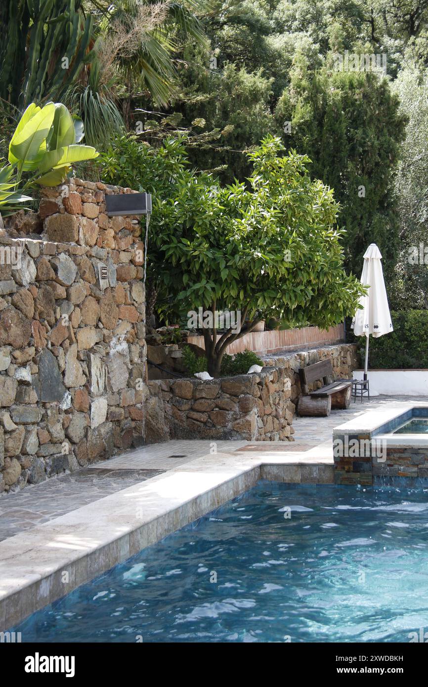 Lussureggiante giardino a bordo piscina in Andalusia, Spagna. Foto Stock