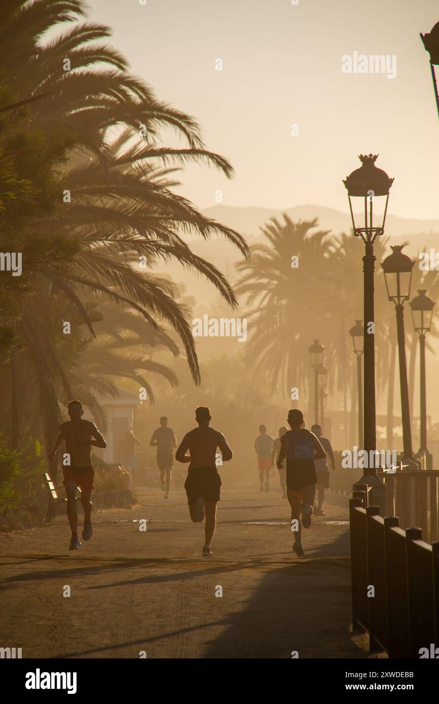 Jogger mattutini lungo la spiaggia di Marbella, Andalusia, Spagna. Foto Stock