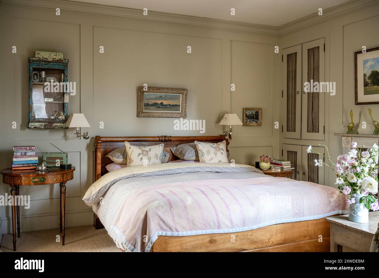 Letto matrimoniale in morbidi rosa e giallo con applique nella casa di Wimbledon, Londra sud-occidentale, Inghilterra, Regno Unito Foto Stock