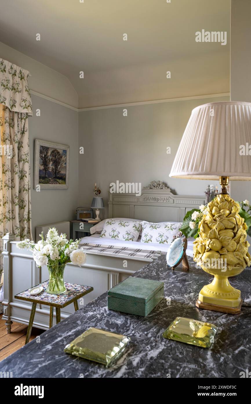 Fresche stampe botaniche con lampada e sottobicchieri su superficie in marmo nella camera da letto di Wimbledon, a sud-ovest di Londra, Inghilterra, Regno Unito. Foto Stock