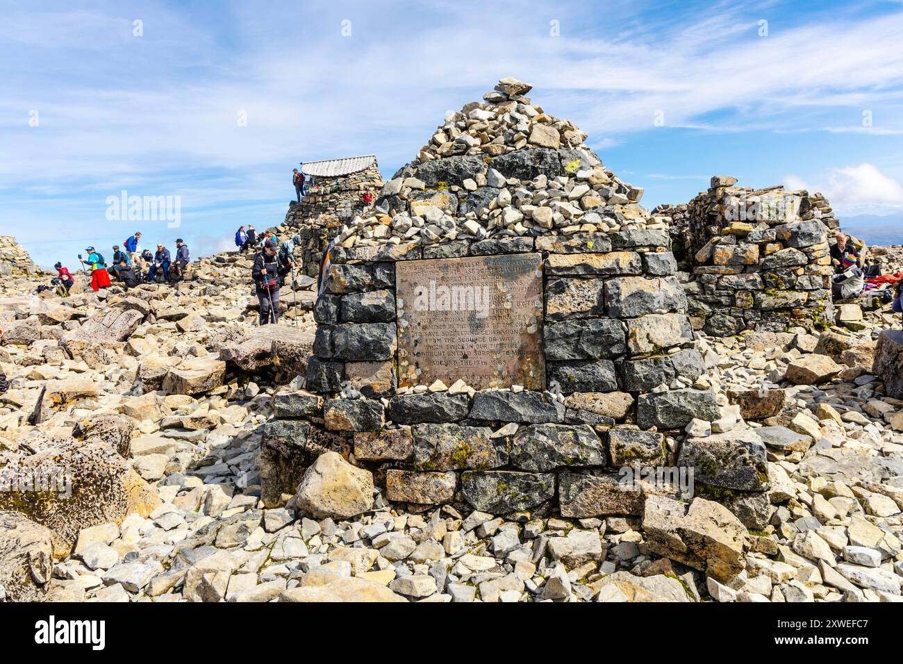 Cairn di pietra con la placca del Ben Nevis Peace Memorial sulle rovine dell'osservatorio della fine del XIX secolo sulla cima del Ben Nevis, Highlands, Scozia Regno Unito Foto Stock