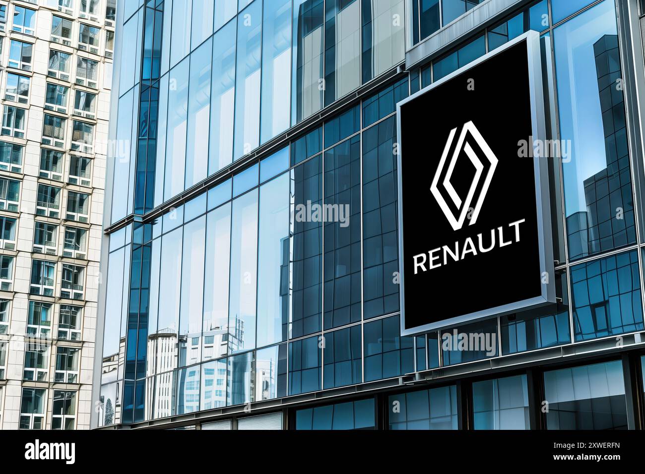 Striscione illuminato con il logo del produttore di auto reanault su un edificio di vetro per uffici. Foto Stock