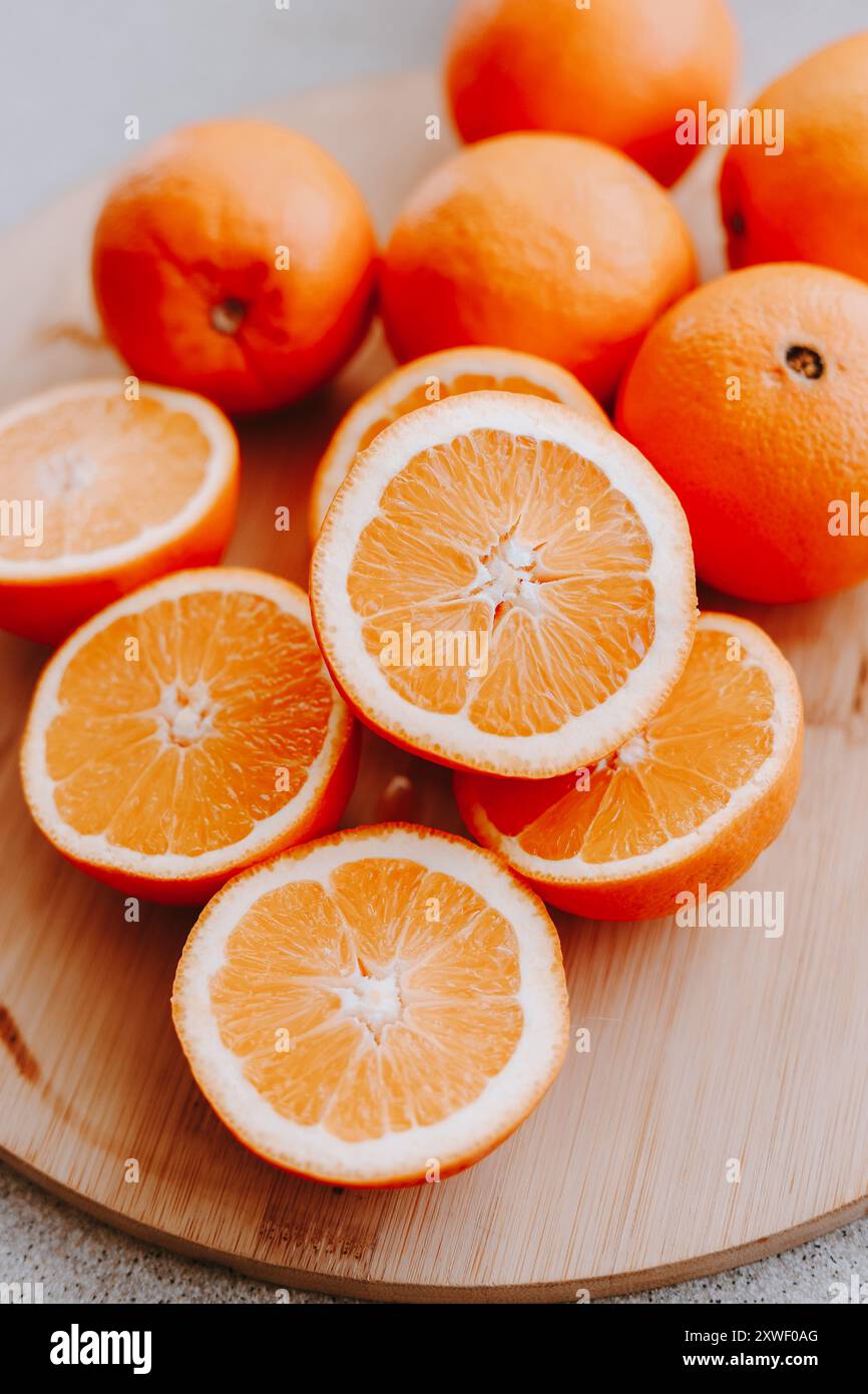 Arance tagliate a fette sul tavolo. La frutta giace su un tagliere di legno. Foto Stock