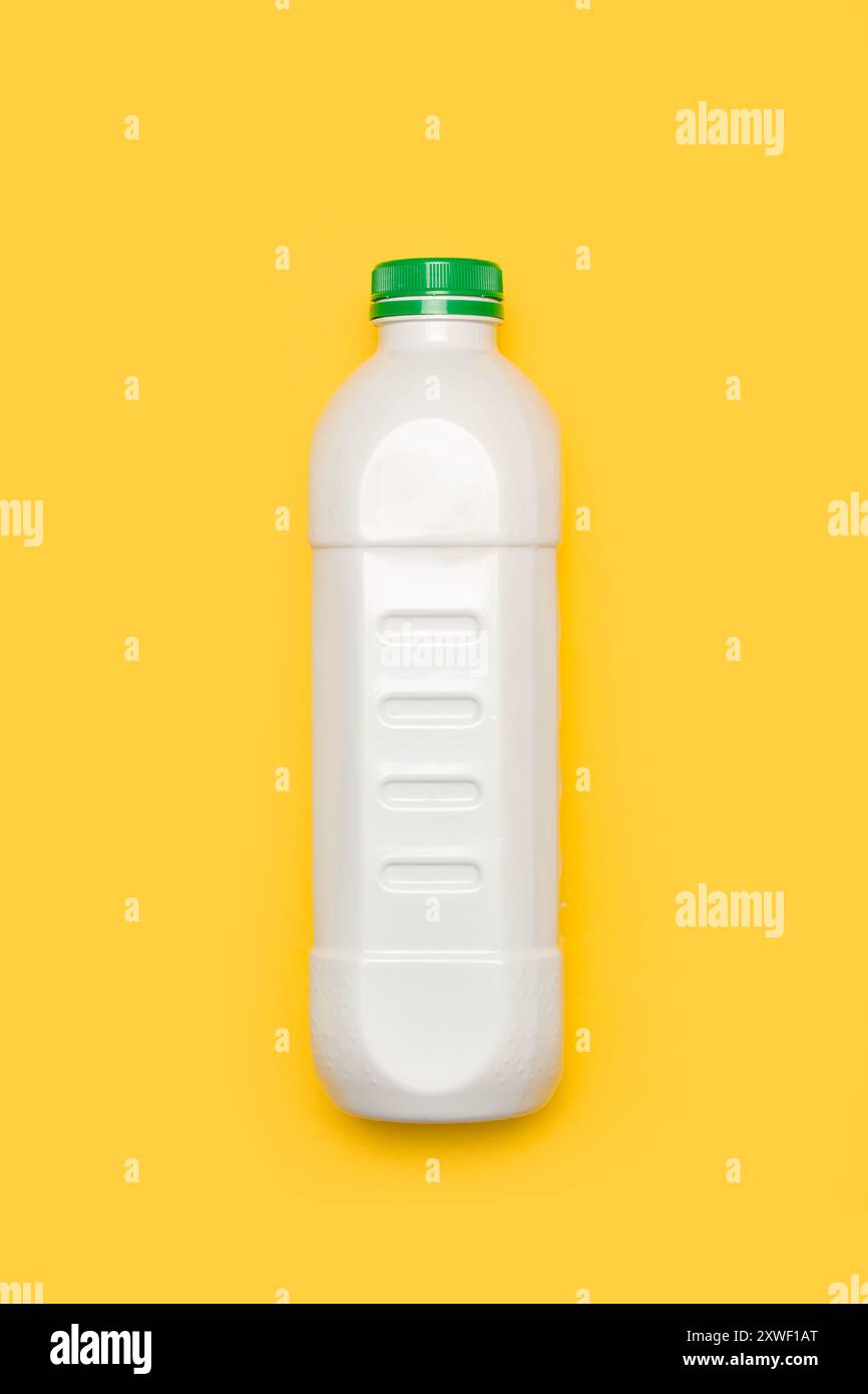 Flacone di plastica bianco con coperchio verde su sfondo giallo Foto Stock