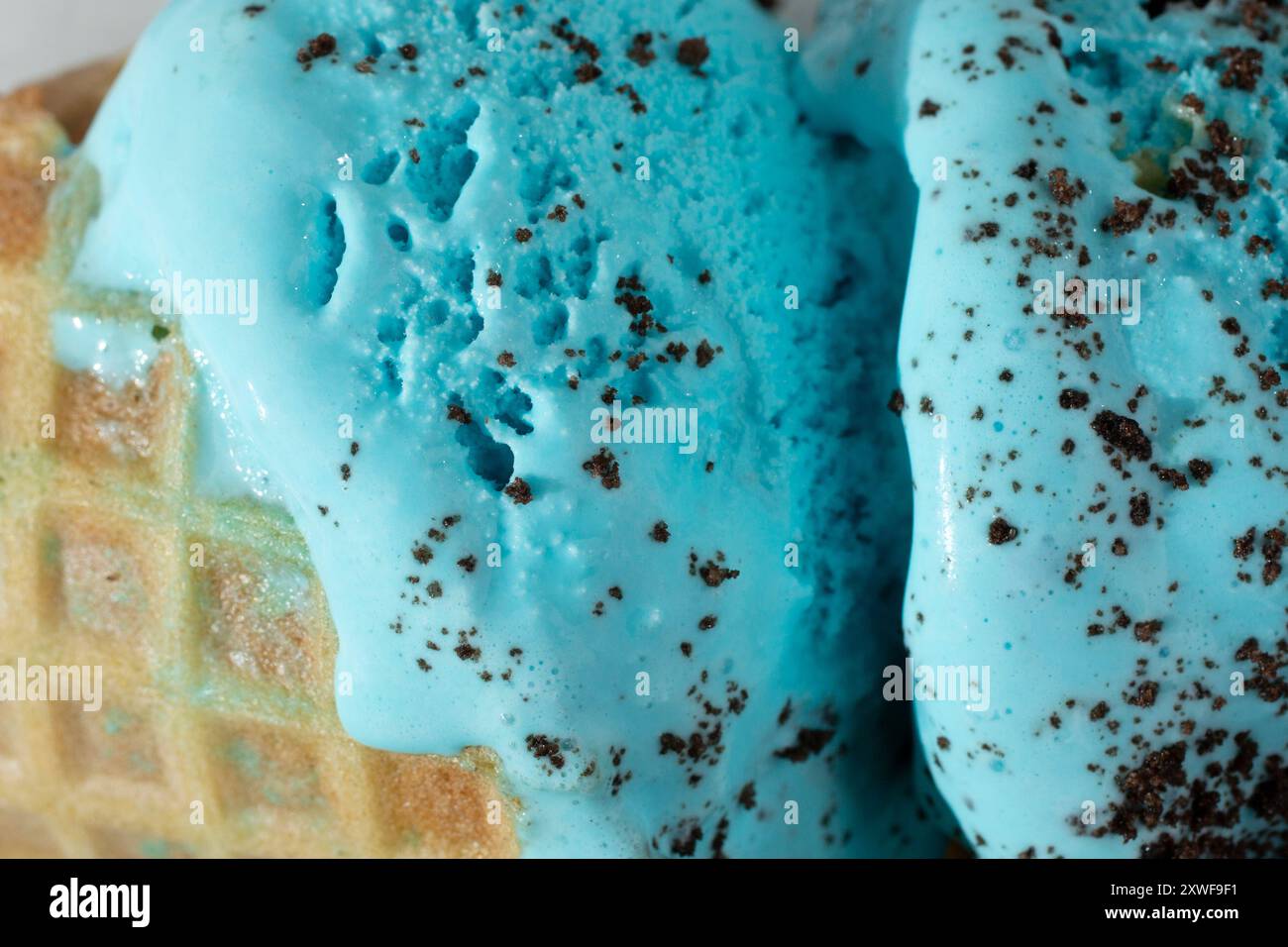 Vista ravvicinata di un gelato con biscotti blu in un cono di waffle. Foto Stock