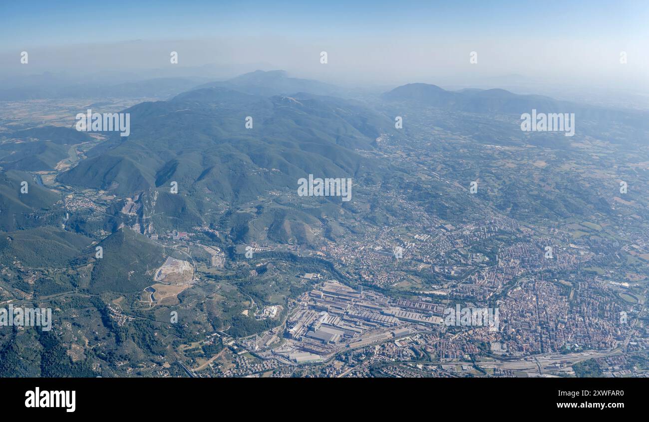 Paesaggio urbano panoramico aereo, da un aereo aliante, con la città storica e industriale di Terni, girato da est in piena luce estiva, Appennini, Terni, Foto Stock