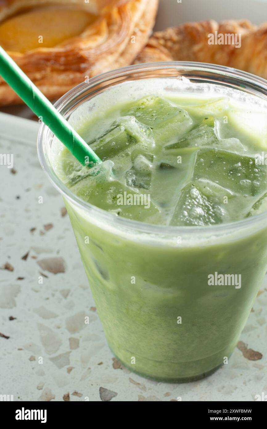 Vista ravvicinata di un latte matcha freddo in una tazza di plastica. Foto Stock