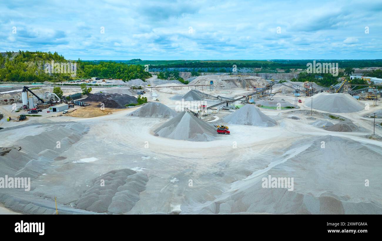 Veduta aerea dell'ampia cava con pali di ghiaia e macchinari Foto Stock