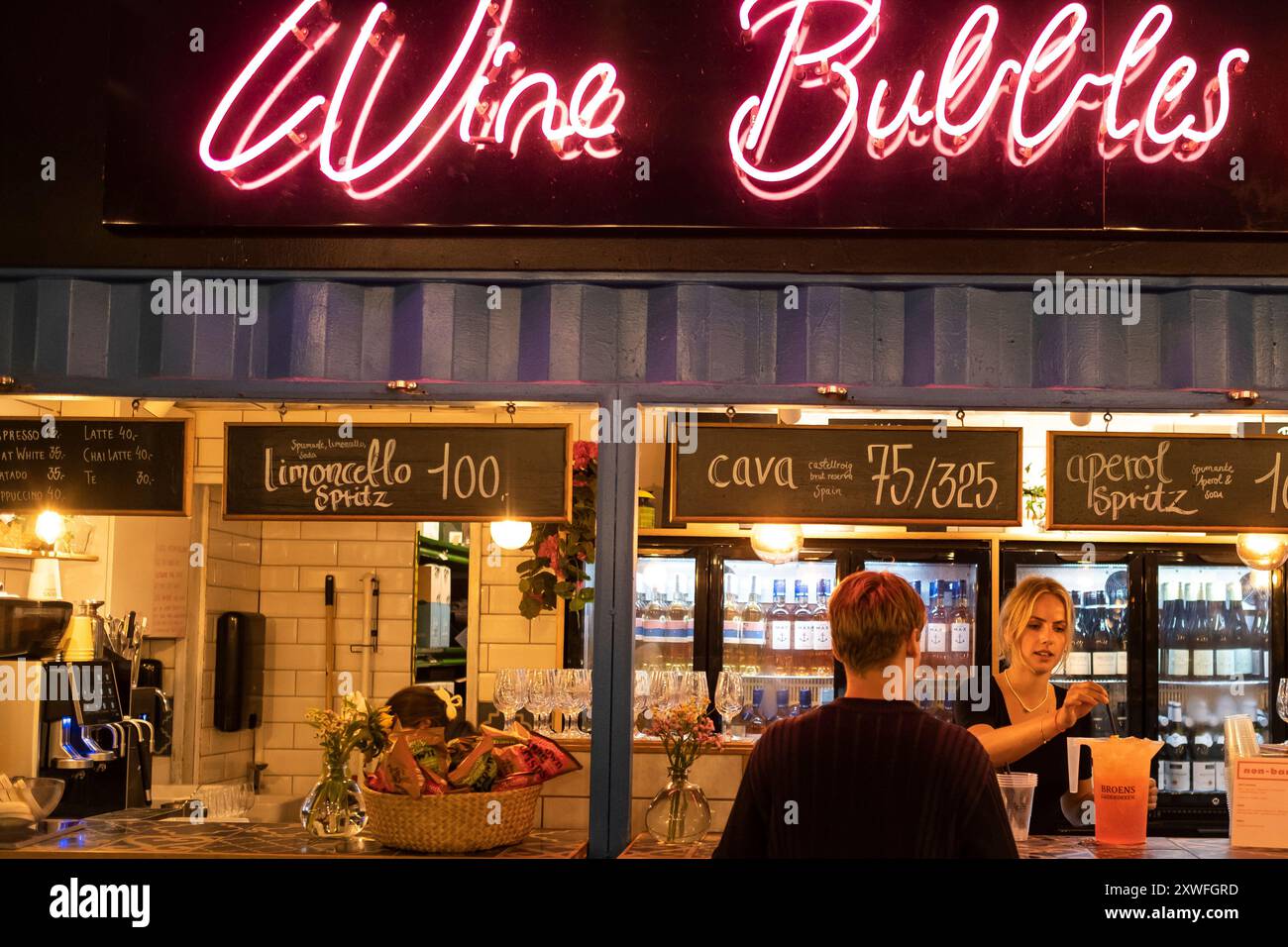 Un barista sorridente mescola una bevanda al mercato alimentare Broens di Copenaghen, Danimarca Foto Stock