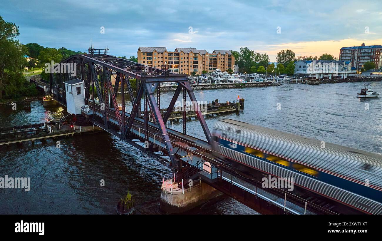 Trenino aereo sul ponte Steel Truss sul fiume con porticciolo Foto Stock