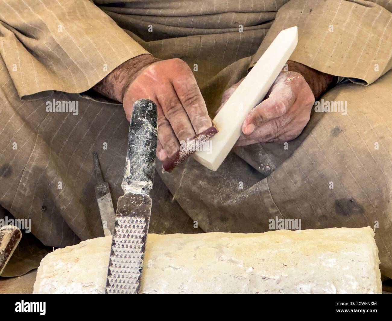 Mani esperte che trasformano un blocco di alabastro egiziano in un capolavoro senza tempo. Questi artigiani, con le loro tecniche ancestrali, portano un pezzo. Foto Stock