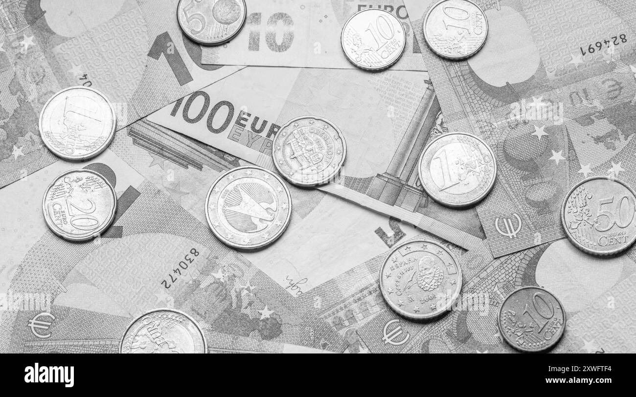 Banconote e monete in euro su tavola Foto Stock