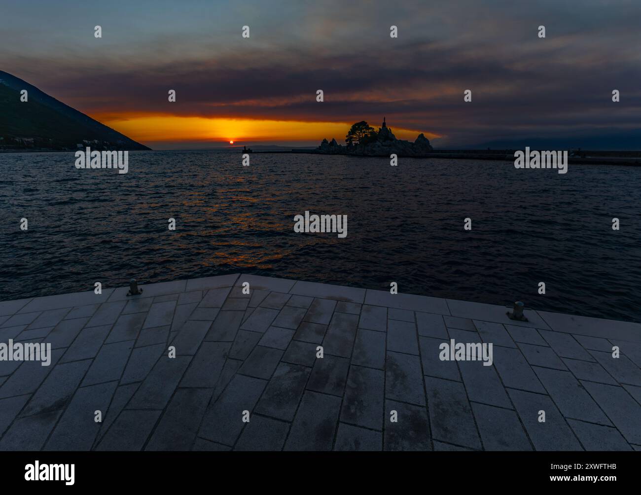 Il sole tramonta sotto l'orizzonte sul mare Adriatico in Croazia Foto Stock