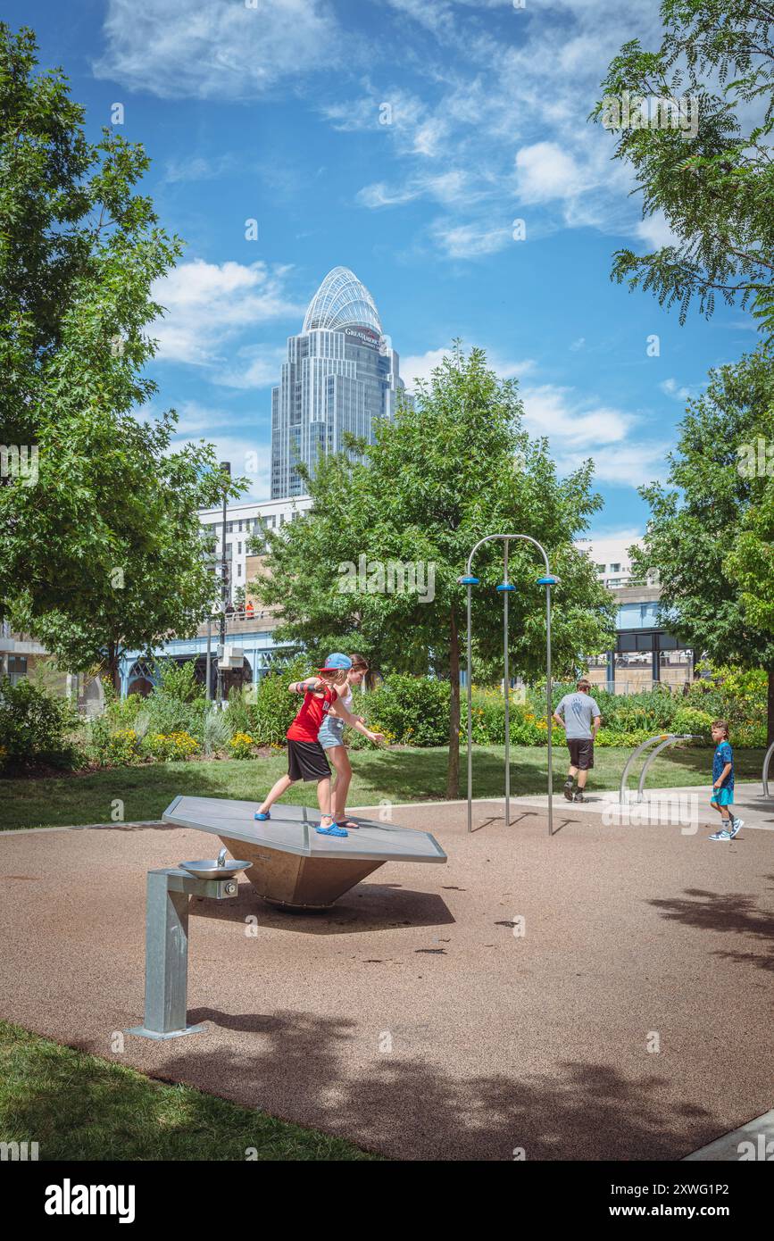 Cincinnati, Ohio, 30 luglio 2022: I bambini giocano nel parco giochi dello Smale Riverfront Park con la Great American Tower sullo sfondo Foto Stock