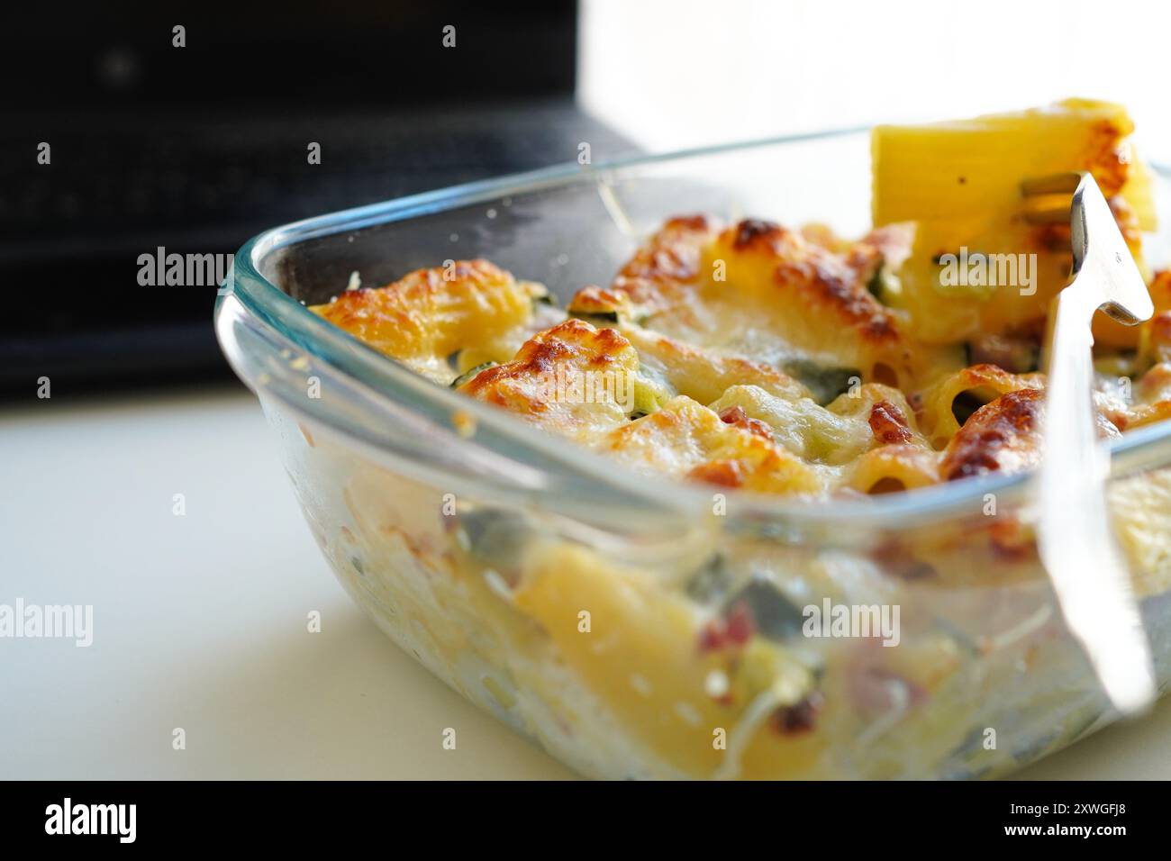 Pranzo con pasta in Tupperware presso il banco dell'ufficio Foto Stock