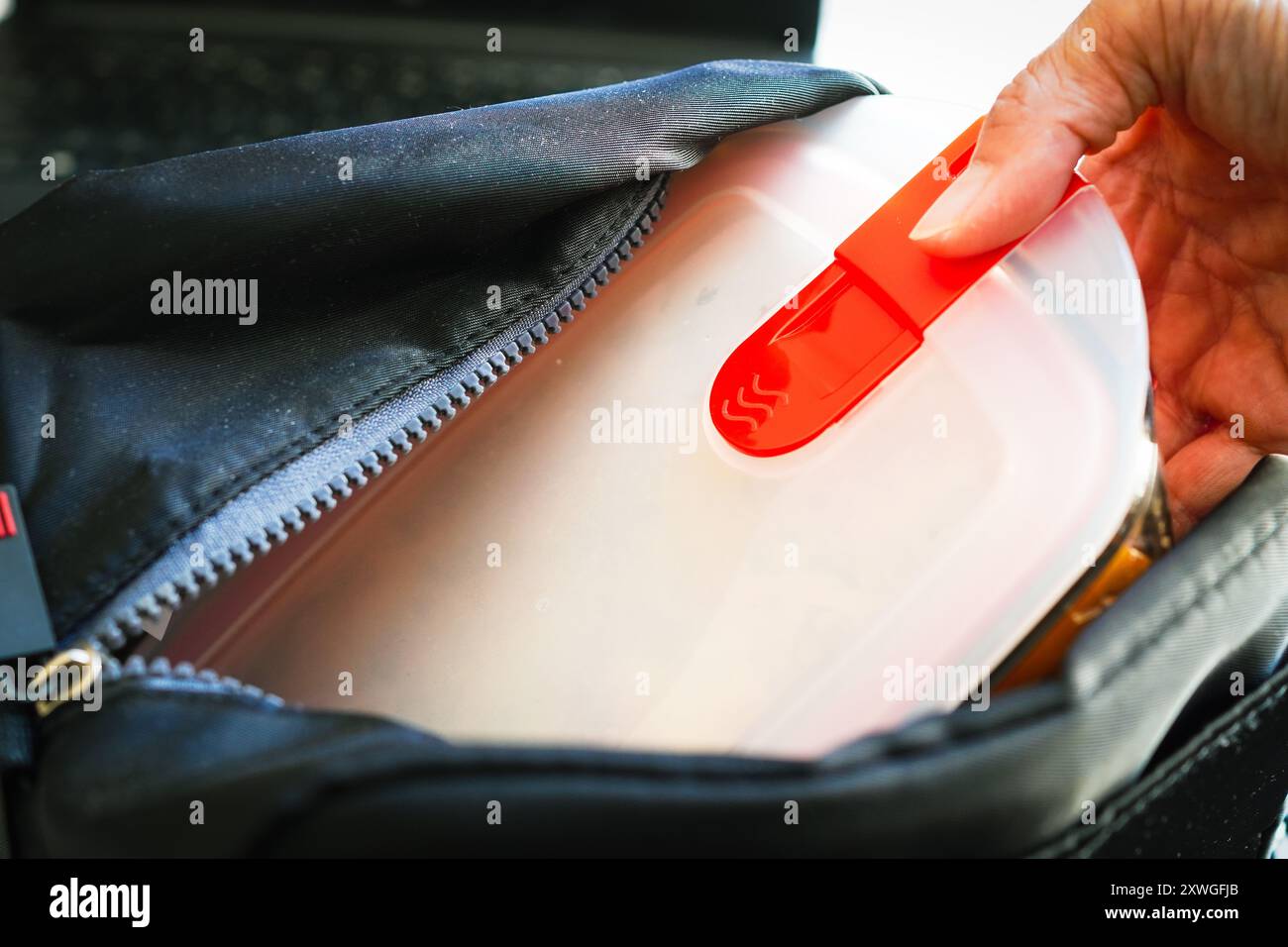 Donna che rimuove i bicchieri termoresistenti in vetro da un sacchetto per conservazione a freddo Foto Stock