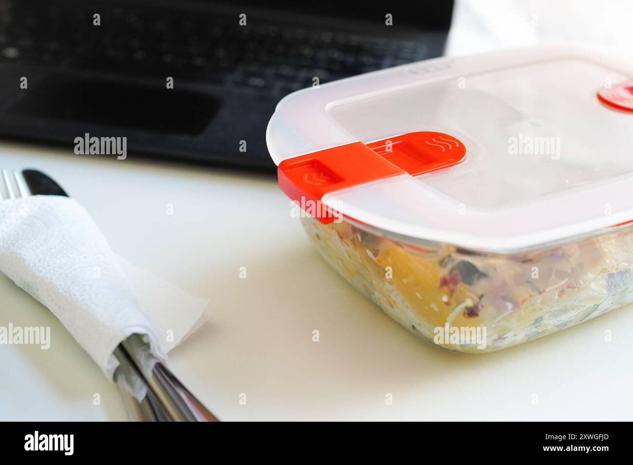 Pranzo con pasta in Tupperware presso il banco dell'ufficio Foto Stock