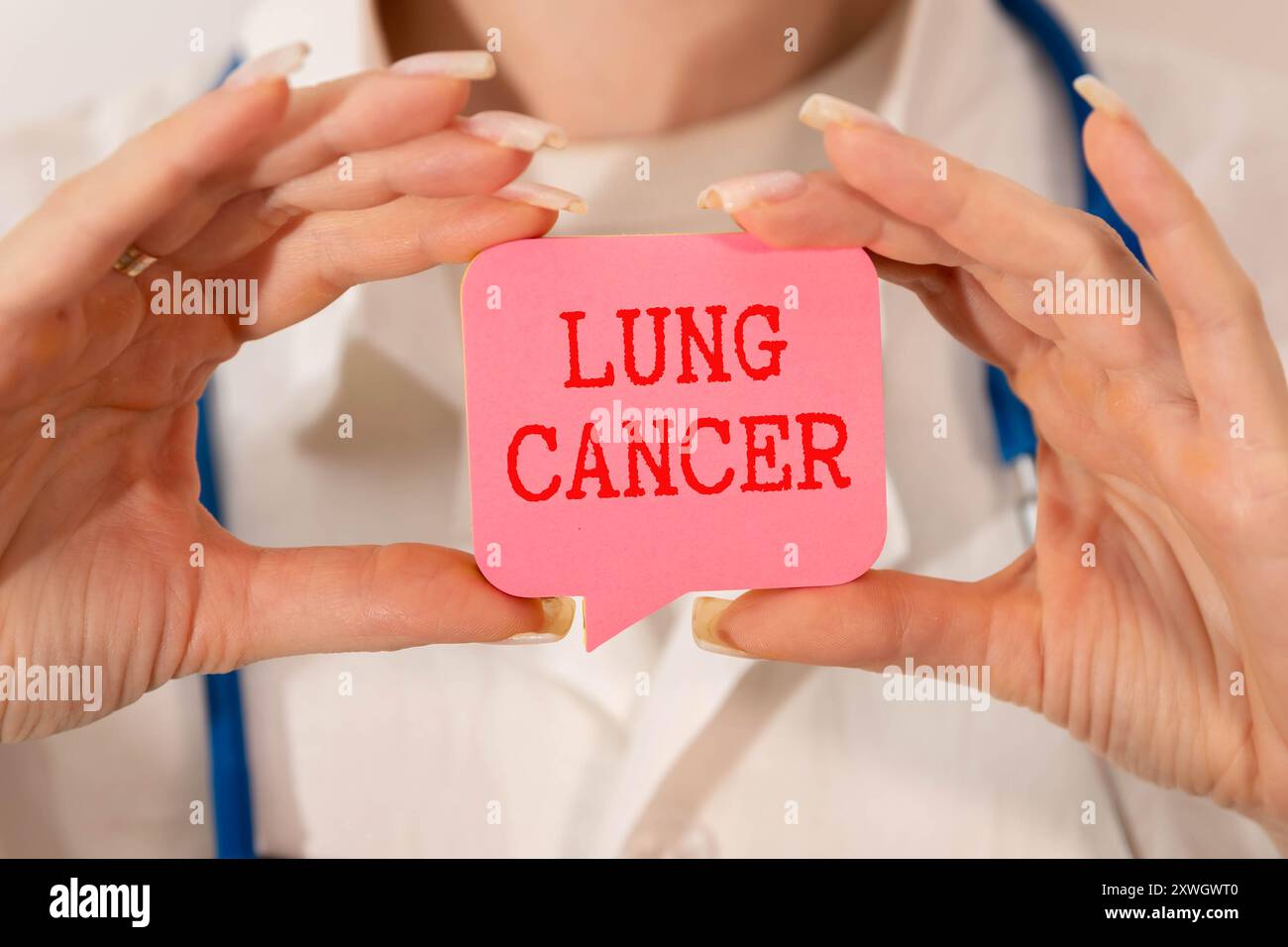 Carta con testo CANCRO POLMONARE su sfondo blu con stetoscopio e pillole. Foto Stock