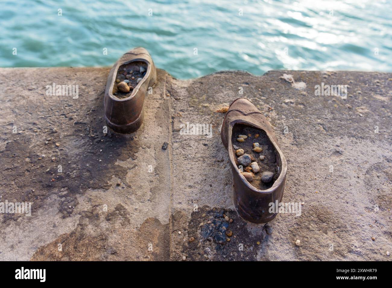 Budapest, Ungheria - 7 luglio 2024: Un paio di scarpe in ferro, modellate in stile anni '1940, lasciate sul bordo della riva del fiume a Budapest. Foto Stock