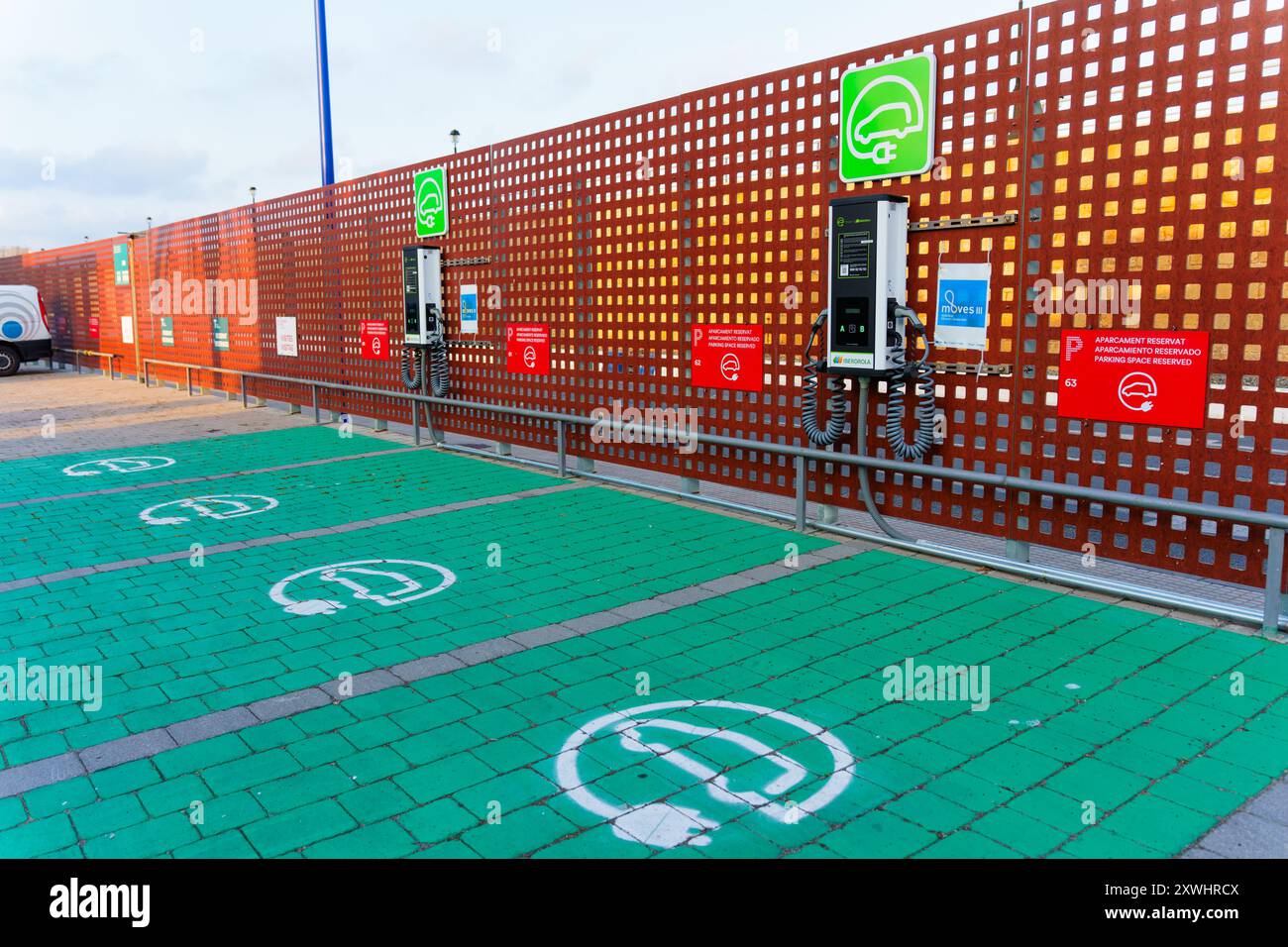 Tarragona, Spagna - 15 luglio 2024: Vista di diverse stazioni di ricarica per veicoli elettrici con simboli di parcheggio riservati dipinti a terra in modo leggero Foto Stock