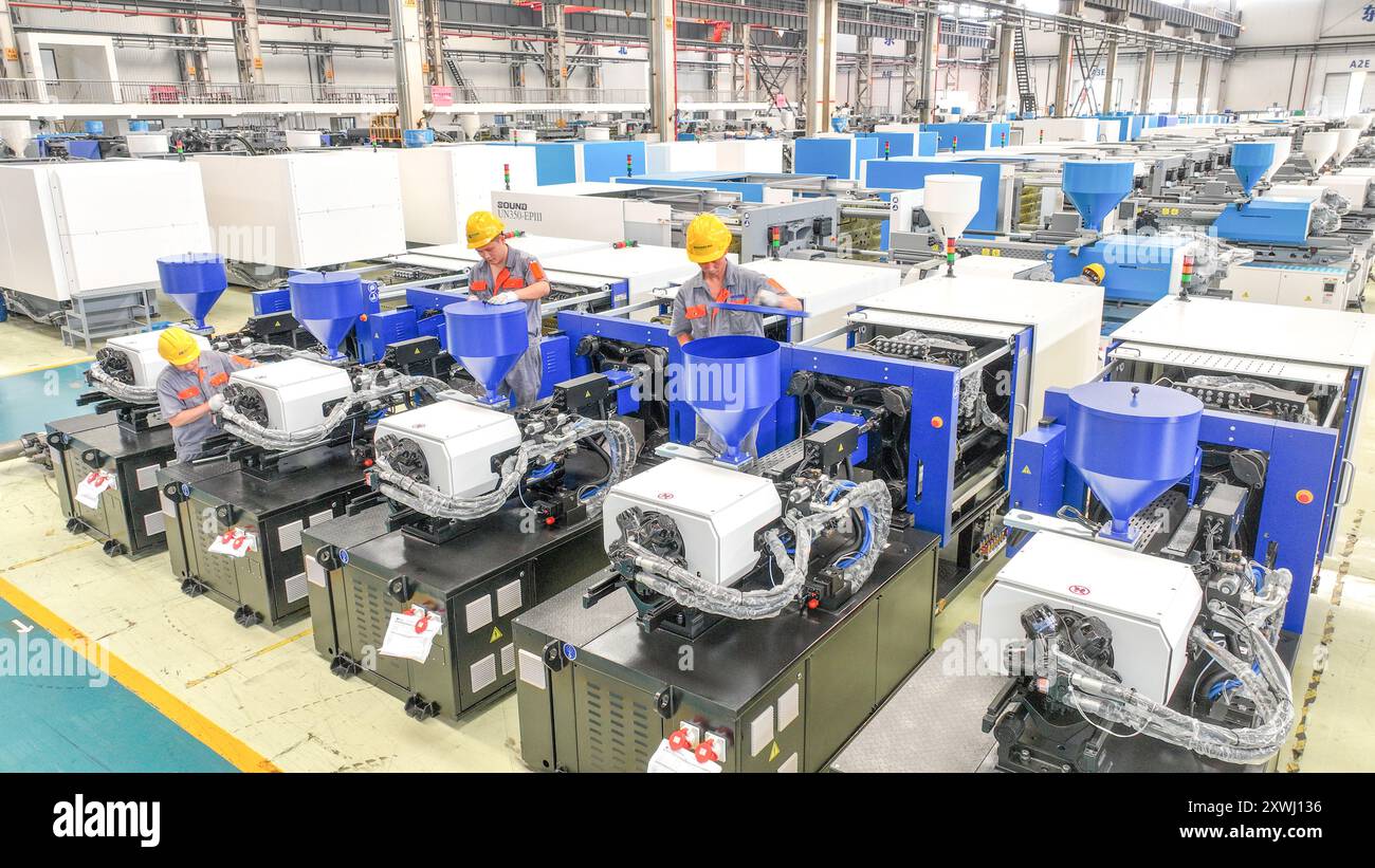 HUZHOU, CINA - 20 AGOSTO 2024 - i lavoratori stanno producendo macchine per lo stampaggio ad iniezione per l'esportazione in un'officina a Huzhou, provincia di Zhejiang, Cina, 2 agosto Foto Stock