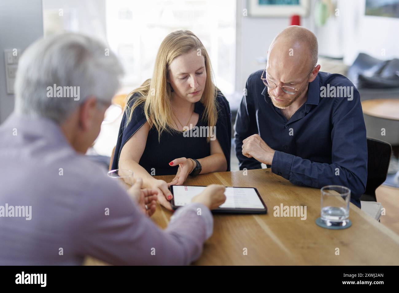 Symbolfoto zum Thema Beratung. Eine junge Frau und ein junger Mann sitzen zu Hause zusammen an einem Tisch und werden beraten. Berlino, 13.08.2024. BER Foto Stock