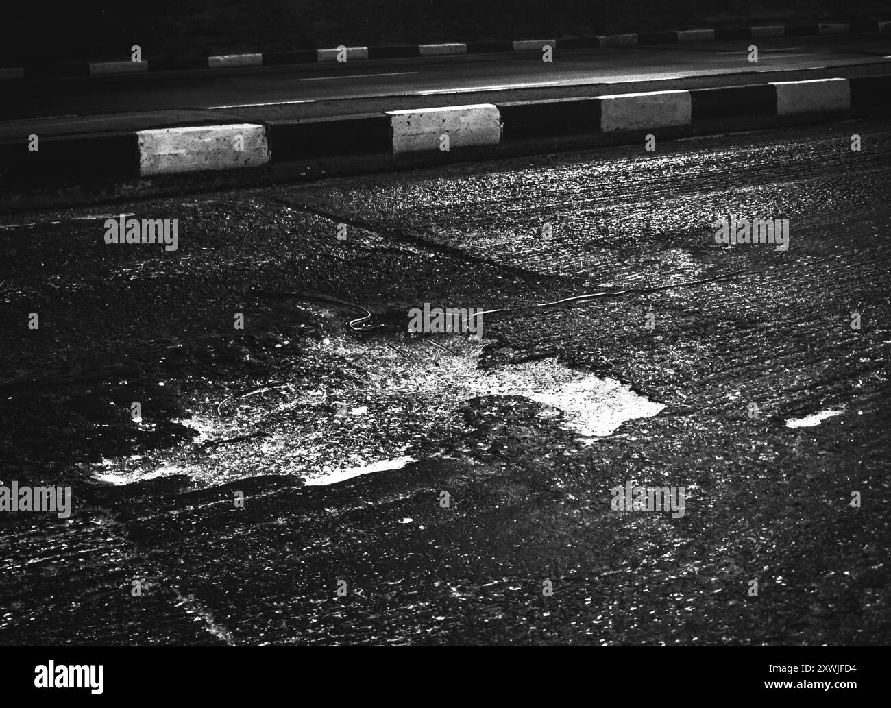 strada asfaltata danneggiata dopo un inverno Foto Stock